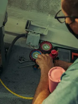 Service engineer performing air conditioning maintenance